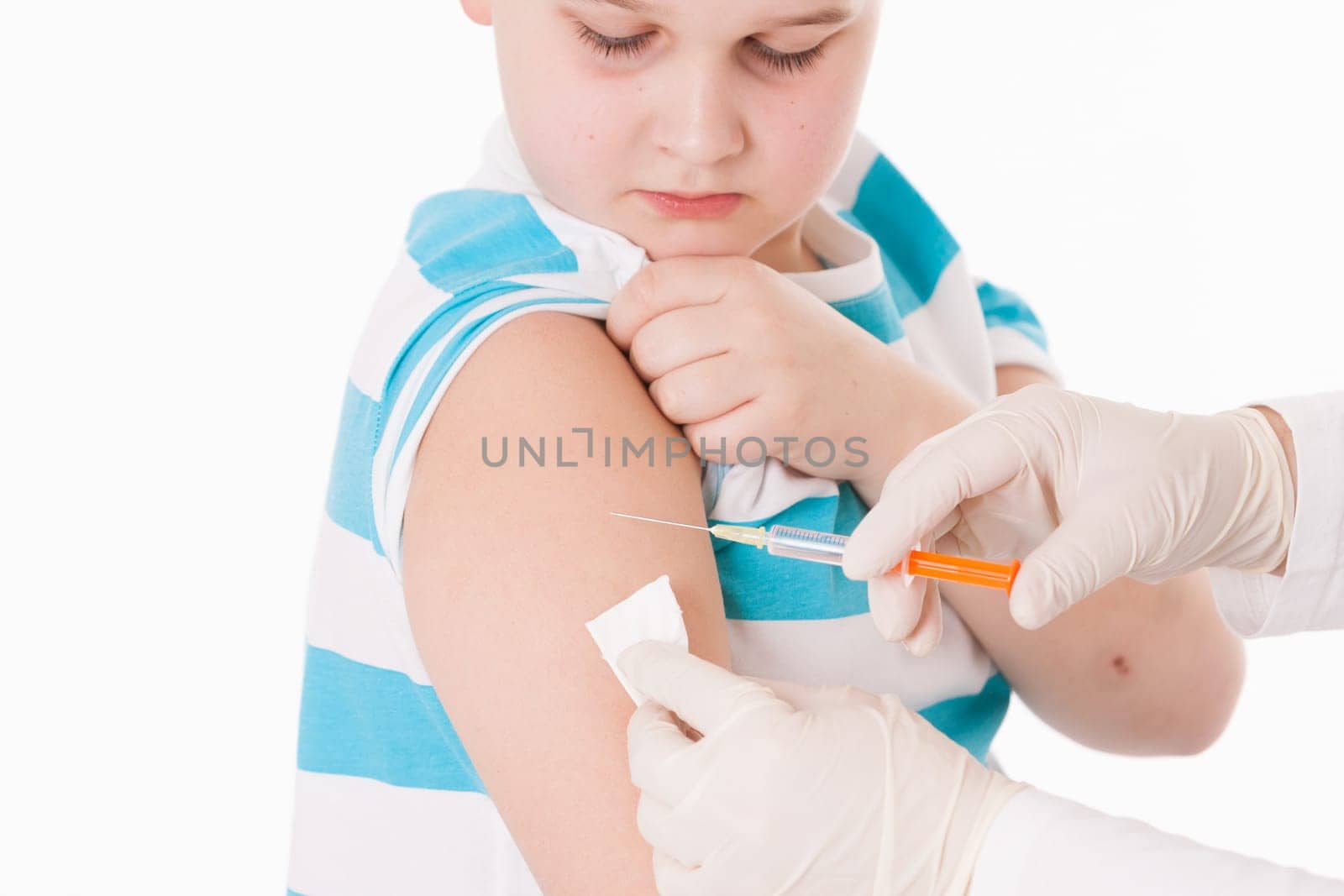 Doctor giving a child injection in arm on isolated image.