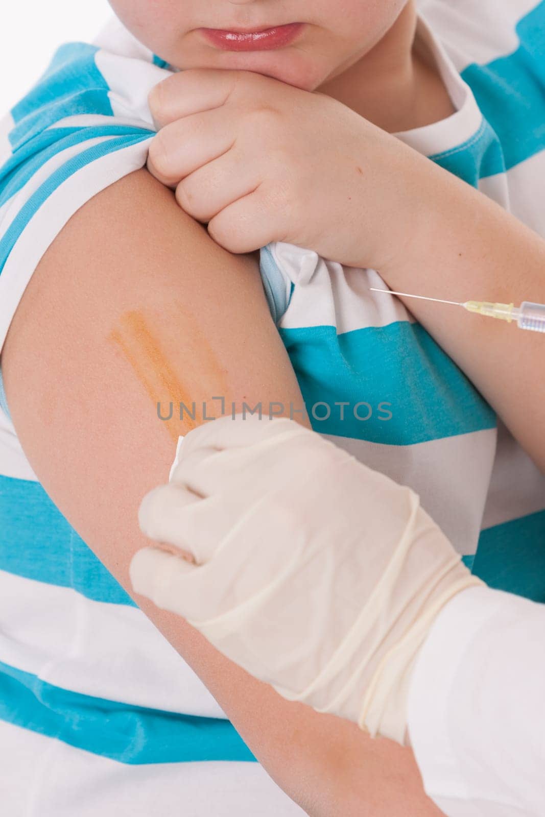 Doctor giving a child injection in arm on isolated image.