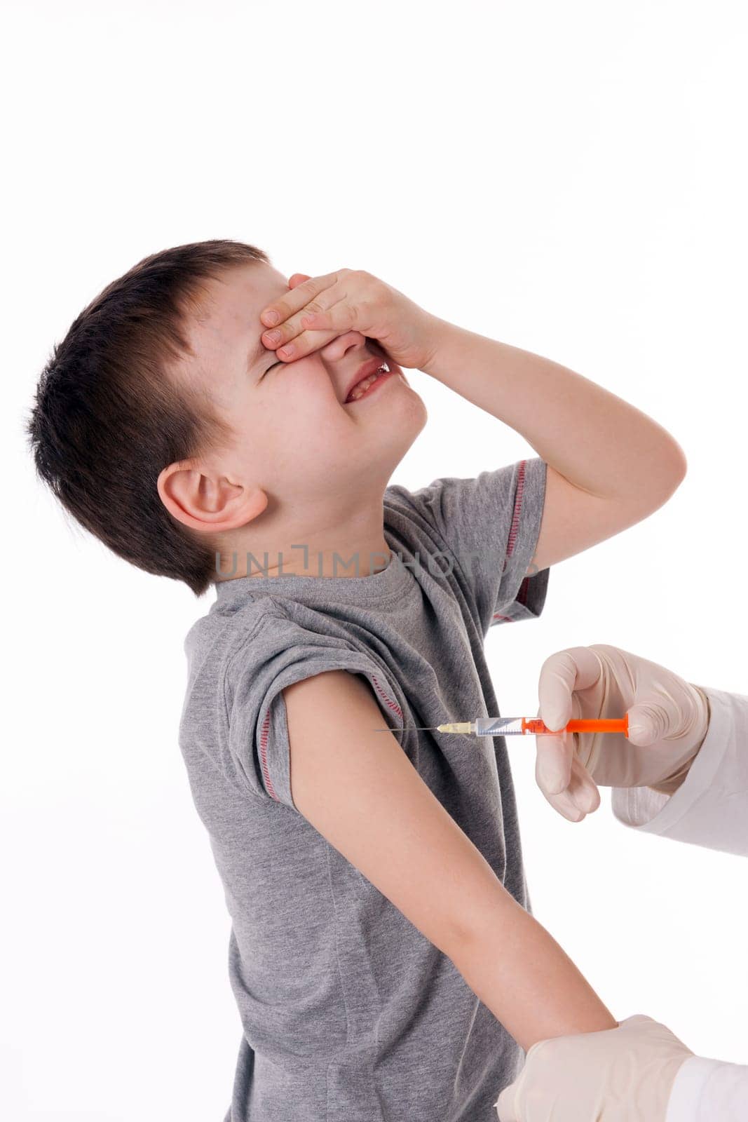 Doctor giving a child injection in arm on isolated image.