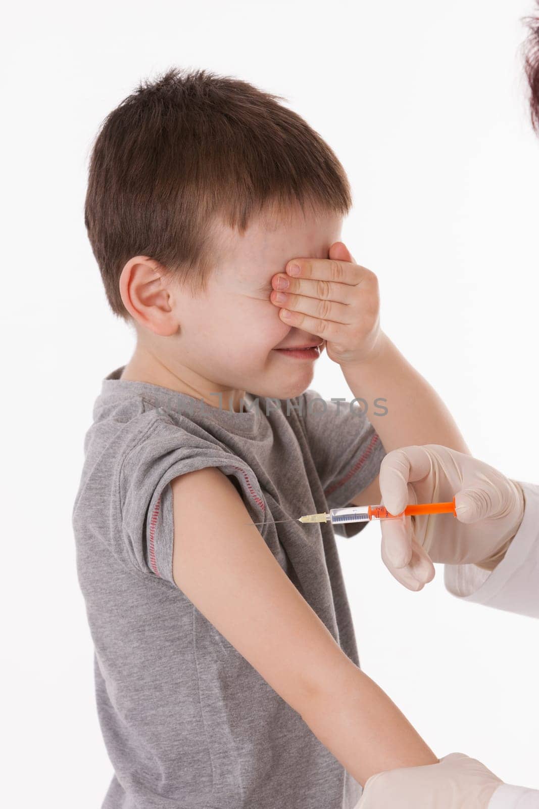 Doctor giving a child injection in arm on isolated image.
