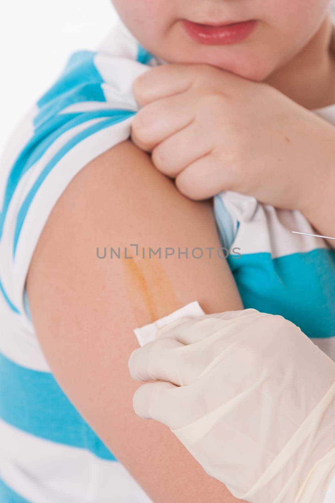 Doctor giving a child injection in arm on isolated image.