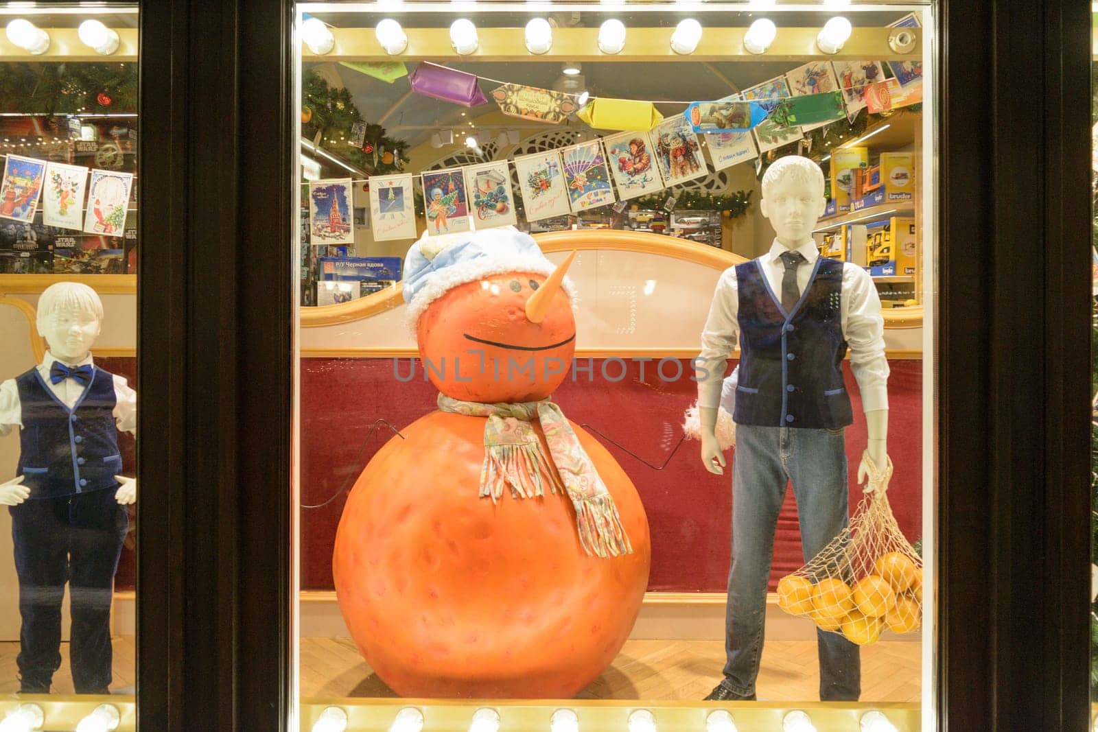 Moscow, Russia - January 05, 2016: Mannequin boy with fruit and orange snowman standing in a shop window "Children GUM"" in Vetoshny lane"