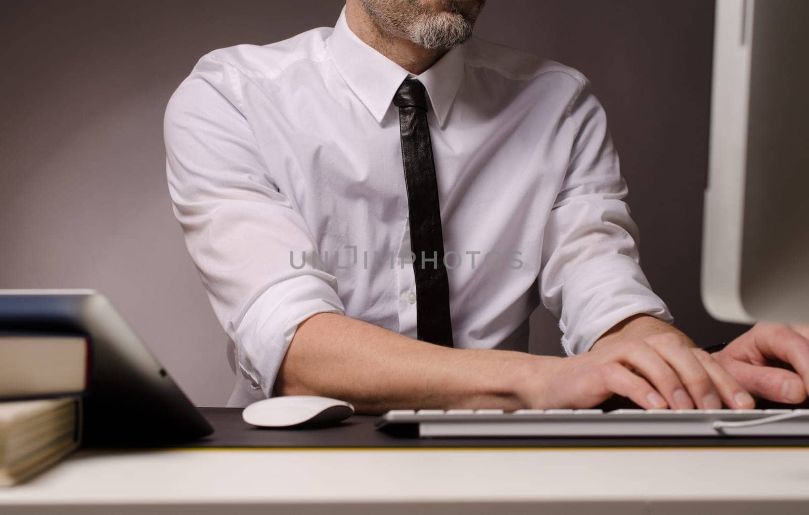 Business man with different devices working on a computer