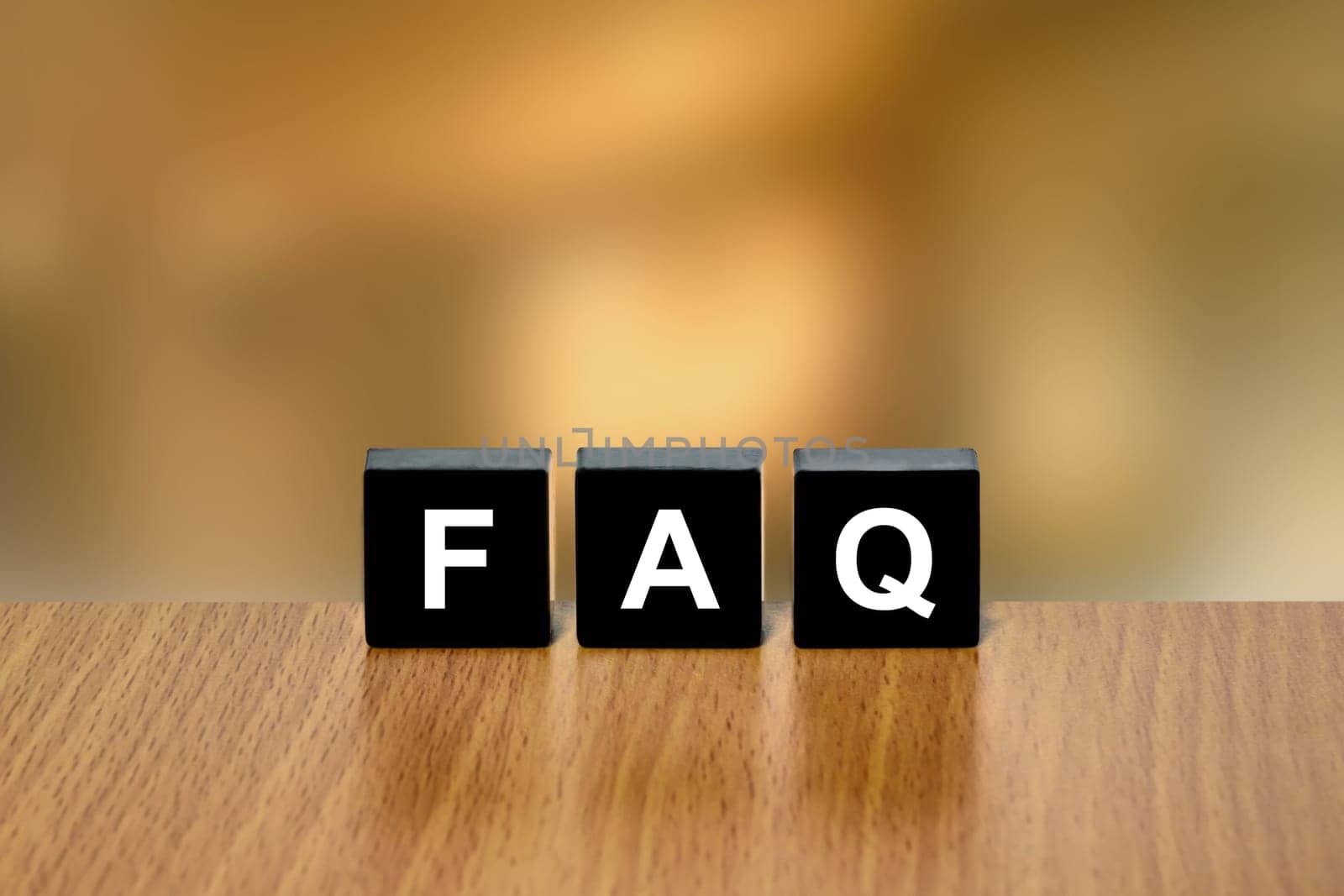 FAQ or Frequently asked questions on black block with blurred background