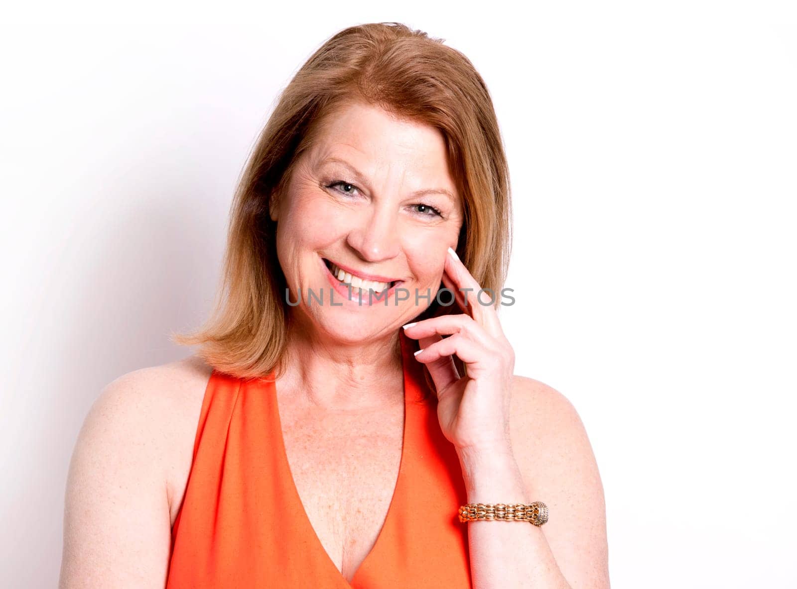 middle aged woman wearing orange dress on white background