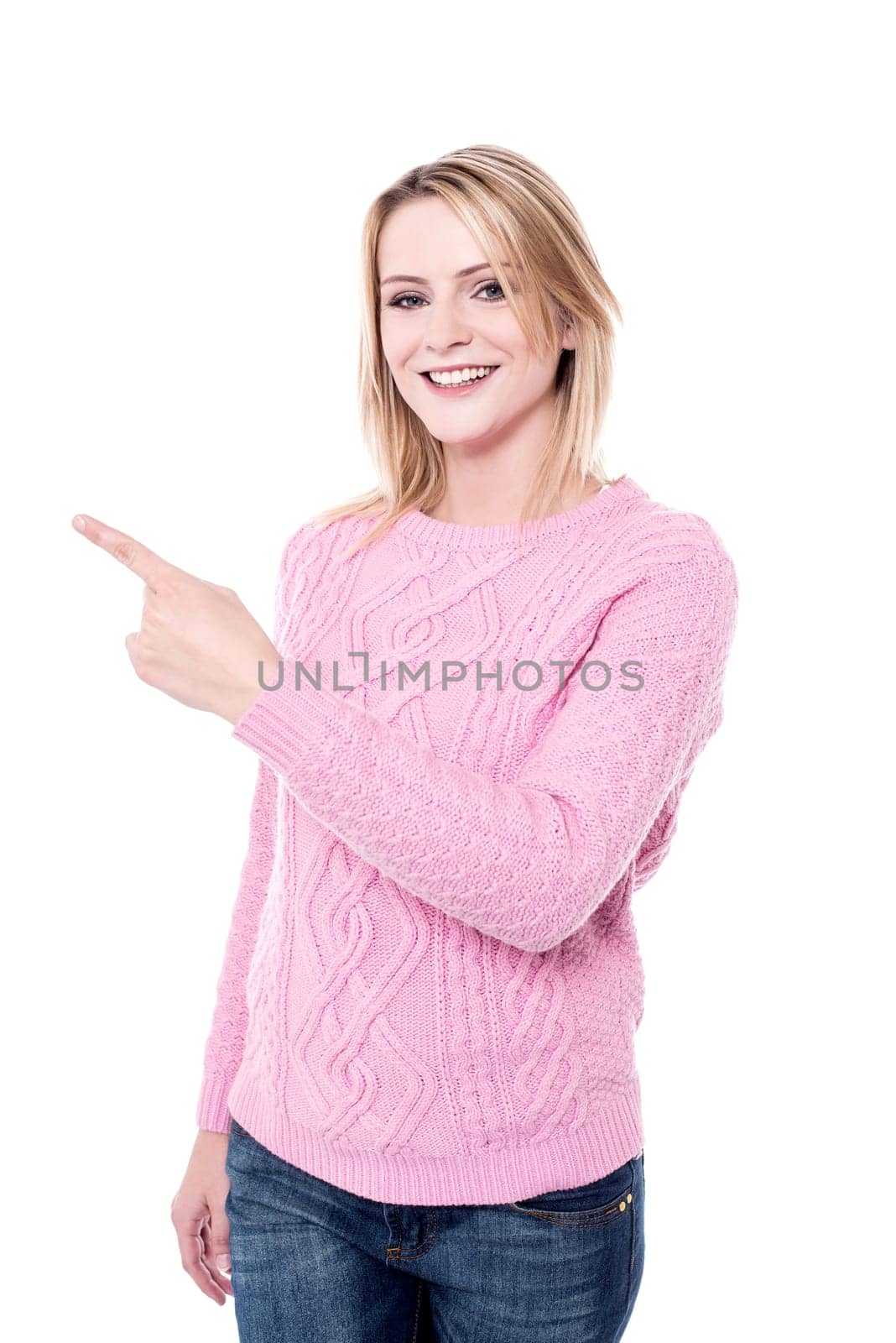 Pretty lady pointing at copy space wearing knitwear