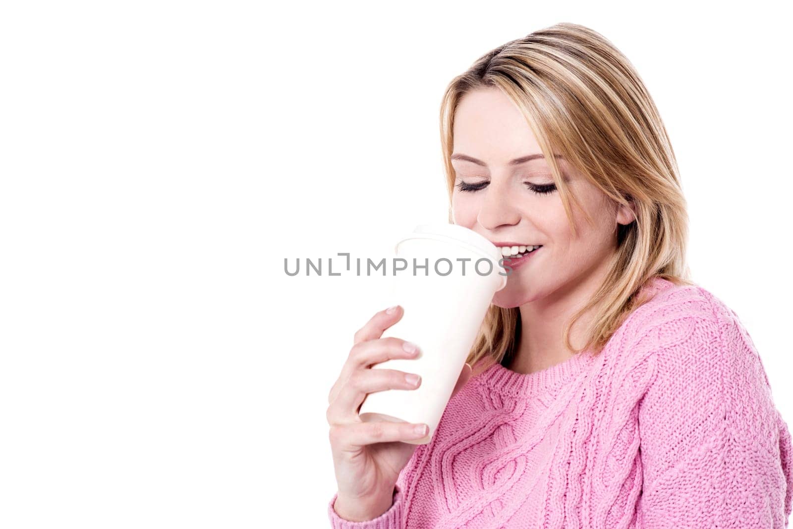 Young model in winter clothes enjoying coffee