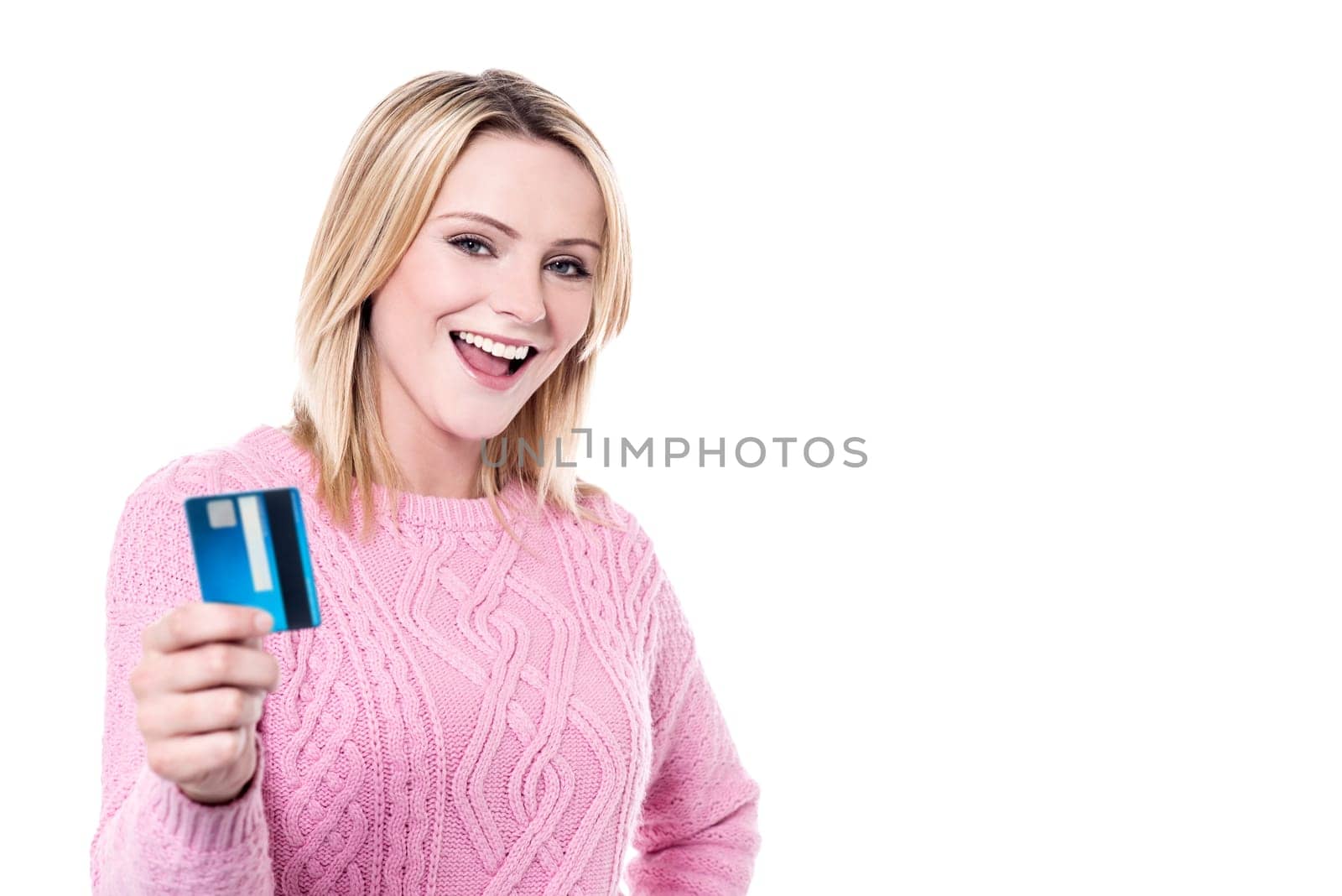 Cheerful young woman displaying credit card to camera