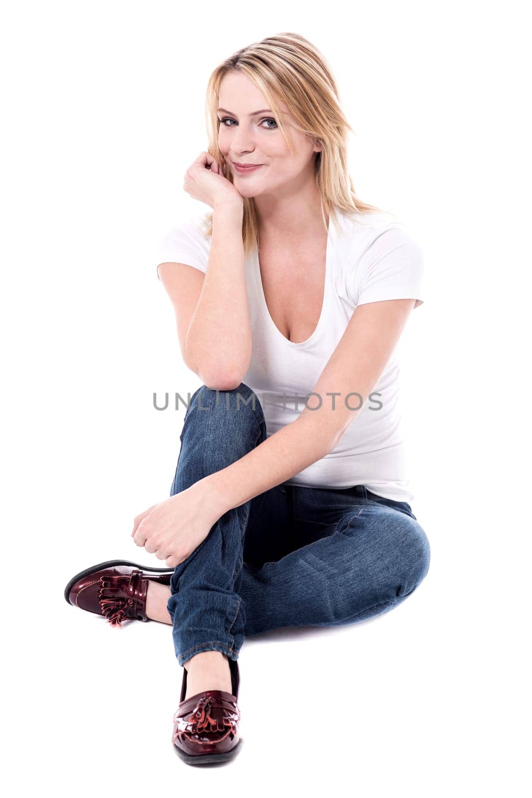Woman sitting on floor and posing with hand on chin