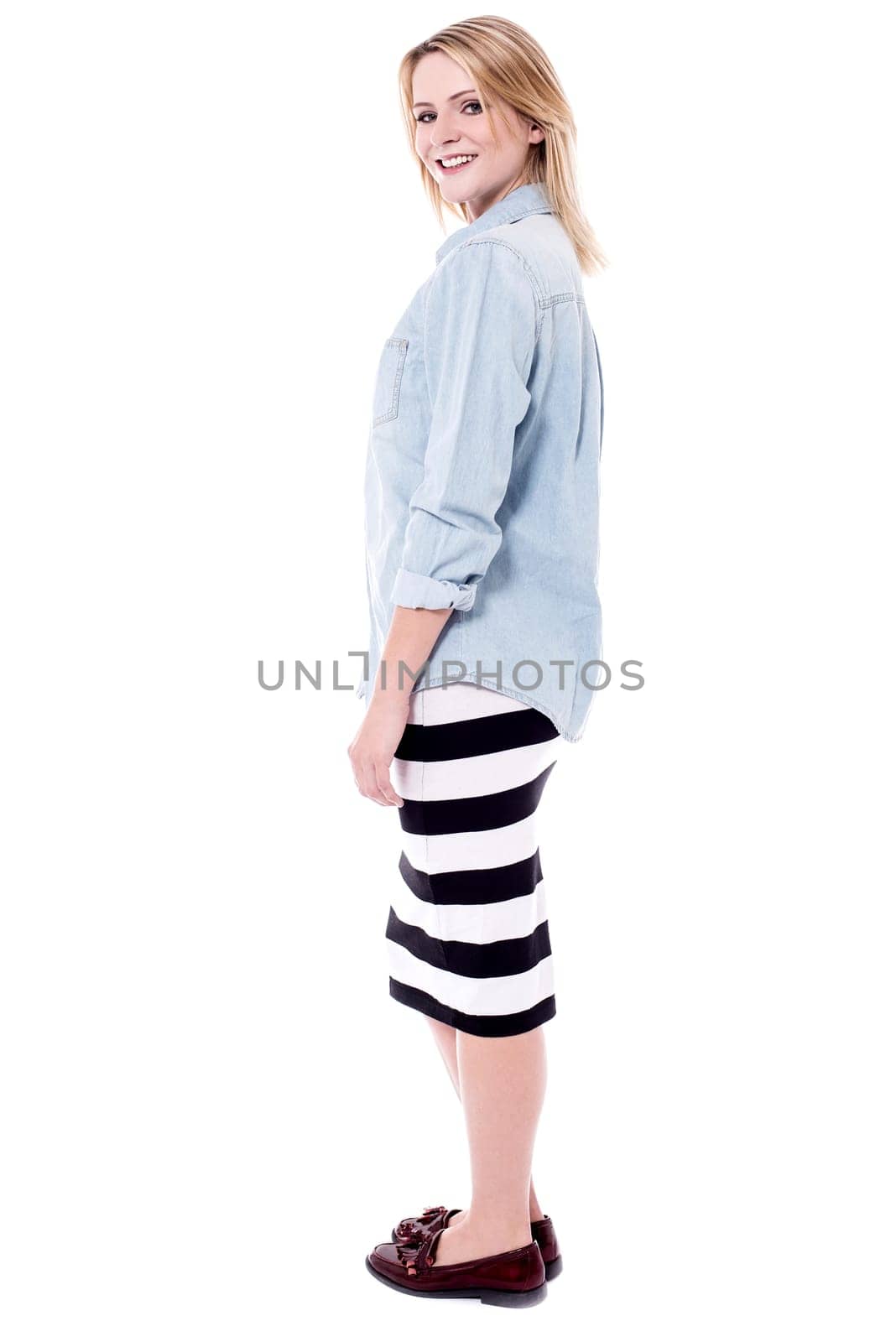 Full length image of young woman posing sideways