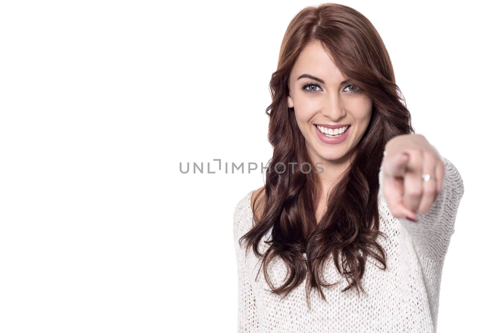 Happy young woman pointing index finger at camera