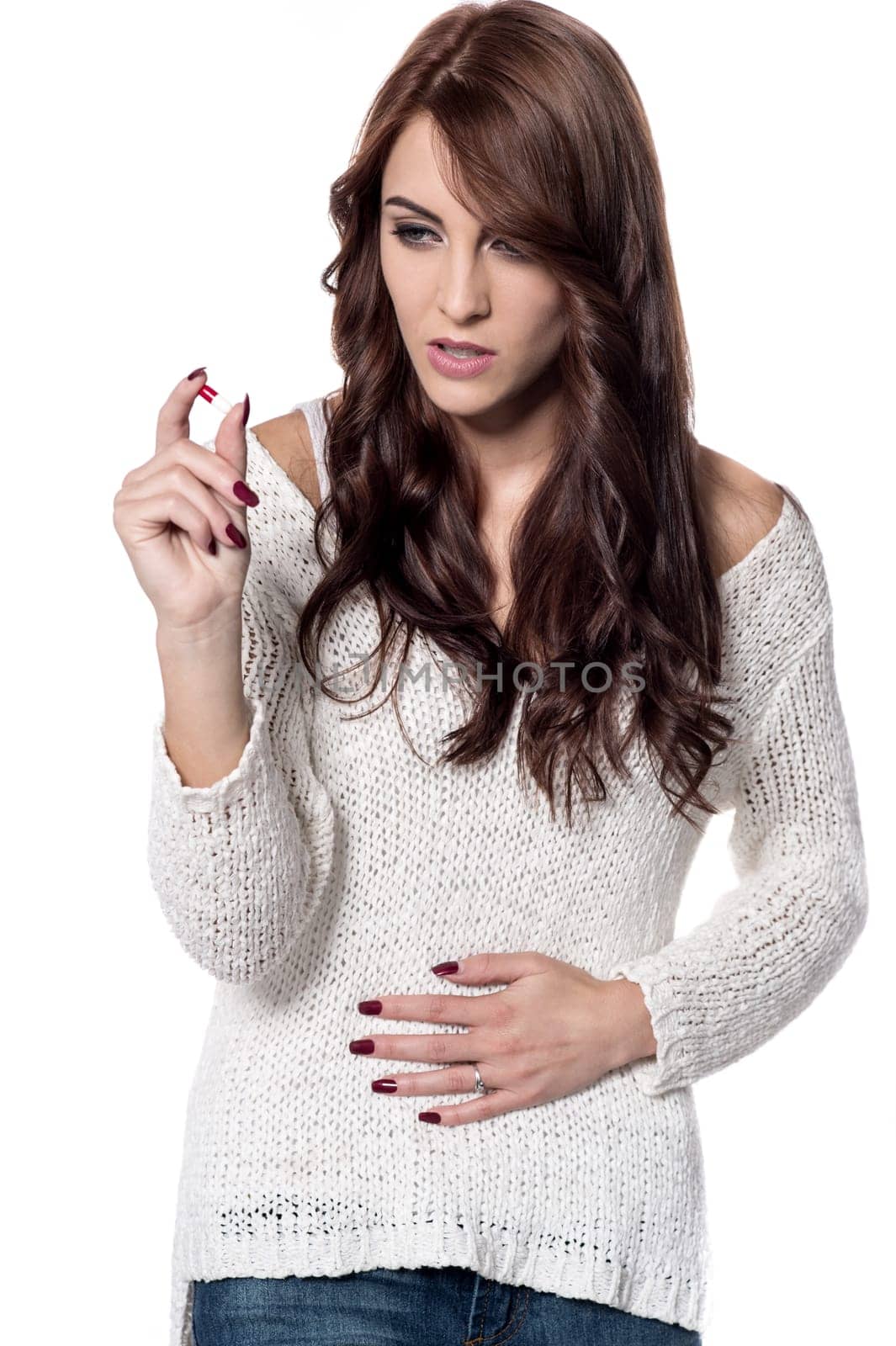 Woman with stomach pain holding medicine pill