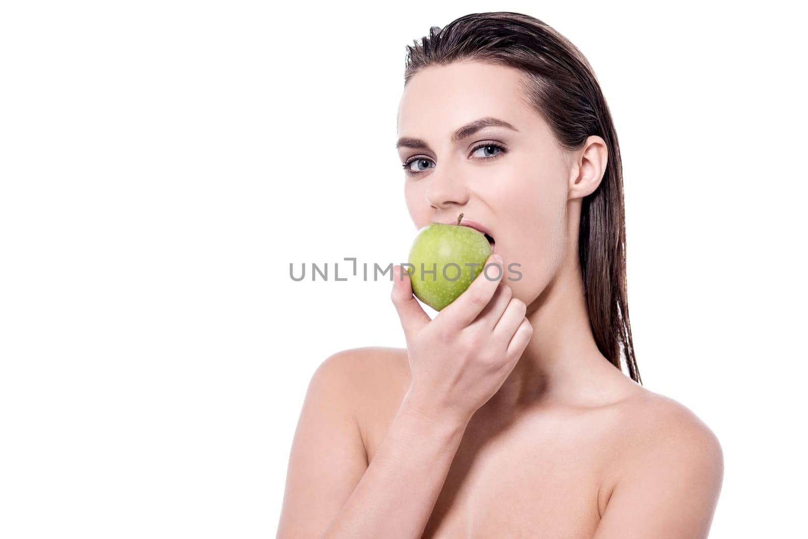 Young woman posing to camera while eating apple