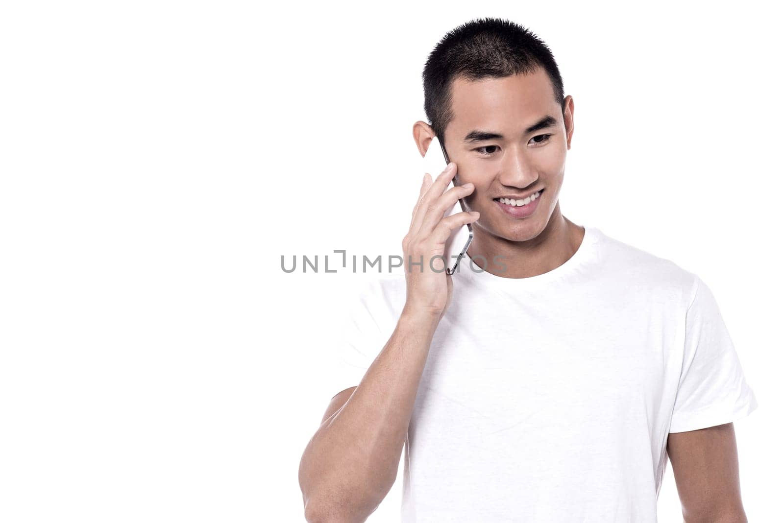Handsome young man speaking on the phone over white