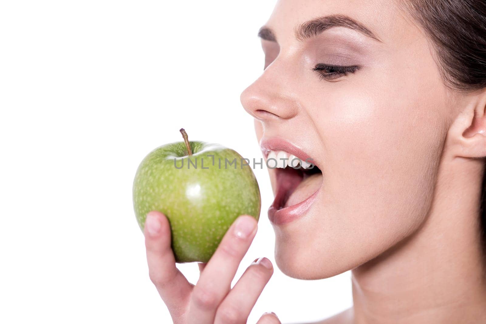 Young woman eating a green apple