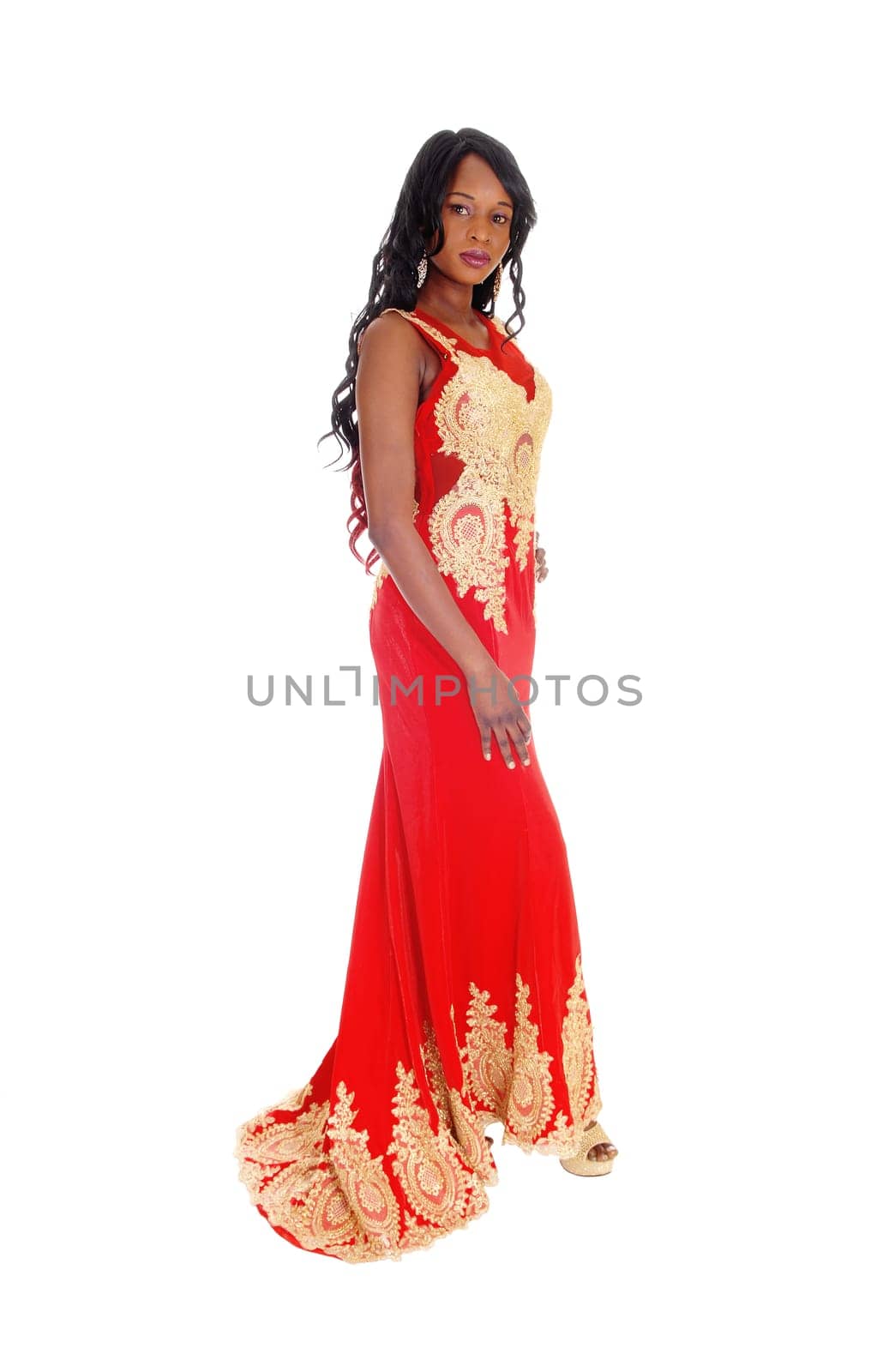 A gorgeous African American woman standing in a long red evening dress.with gold embroideries and long black hair isolated for white background..