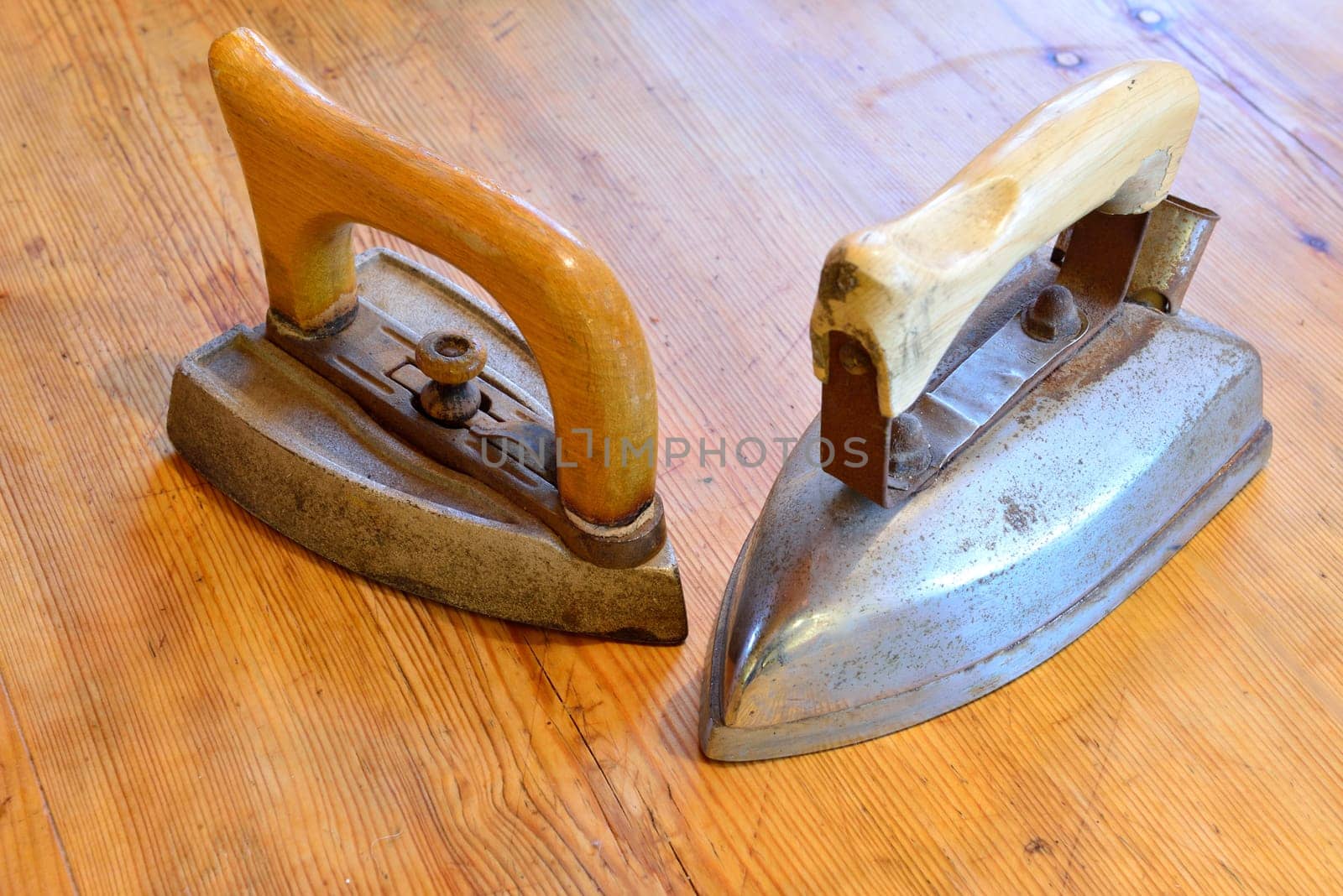 Two old irons on an wooden table
