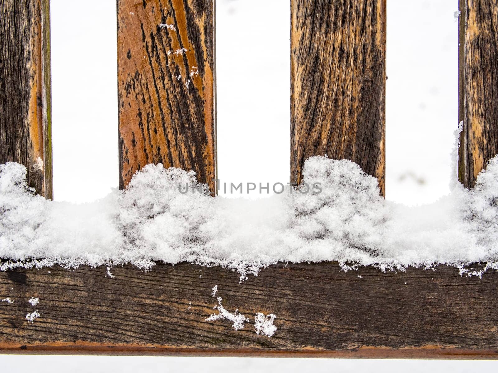 Detail of weathered wooden bench covered in snow, winter time illustration