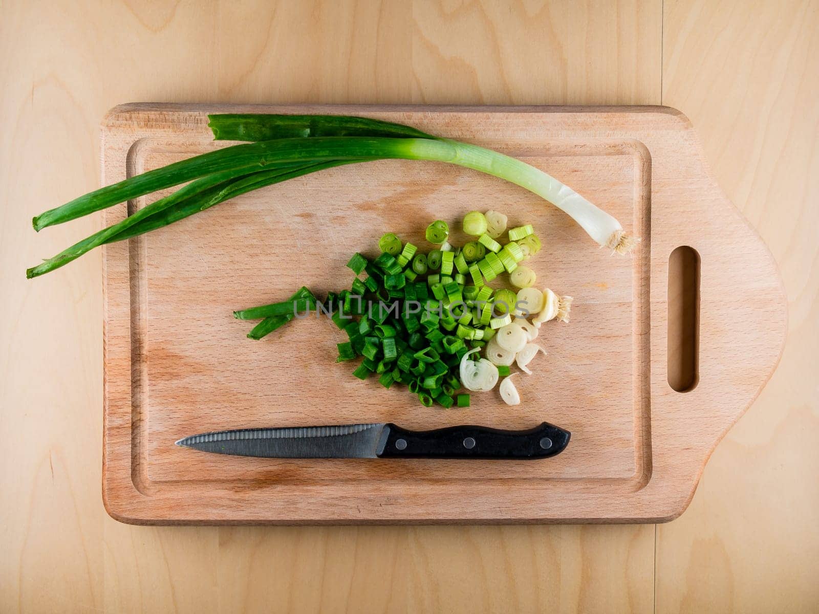 Heart shaped pile of bunching onion on the wooden board, from the top view, healthy life style