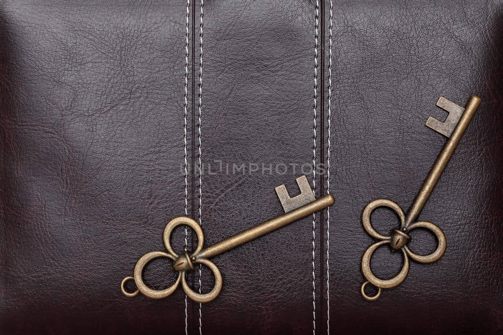 Vintage door key on a brown leather background