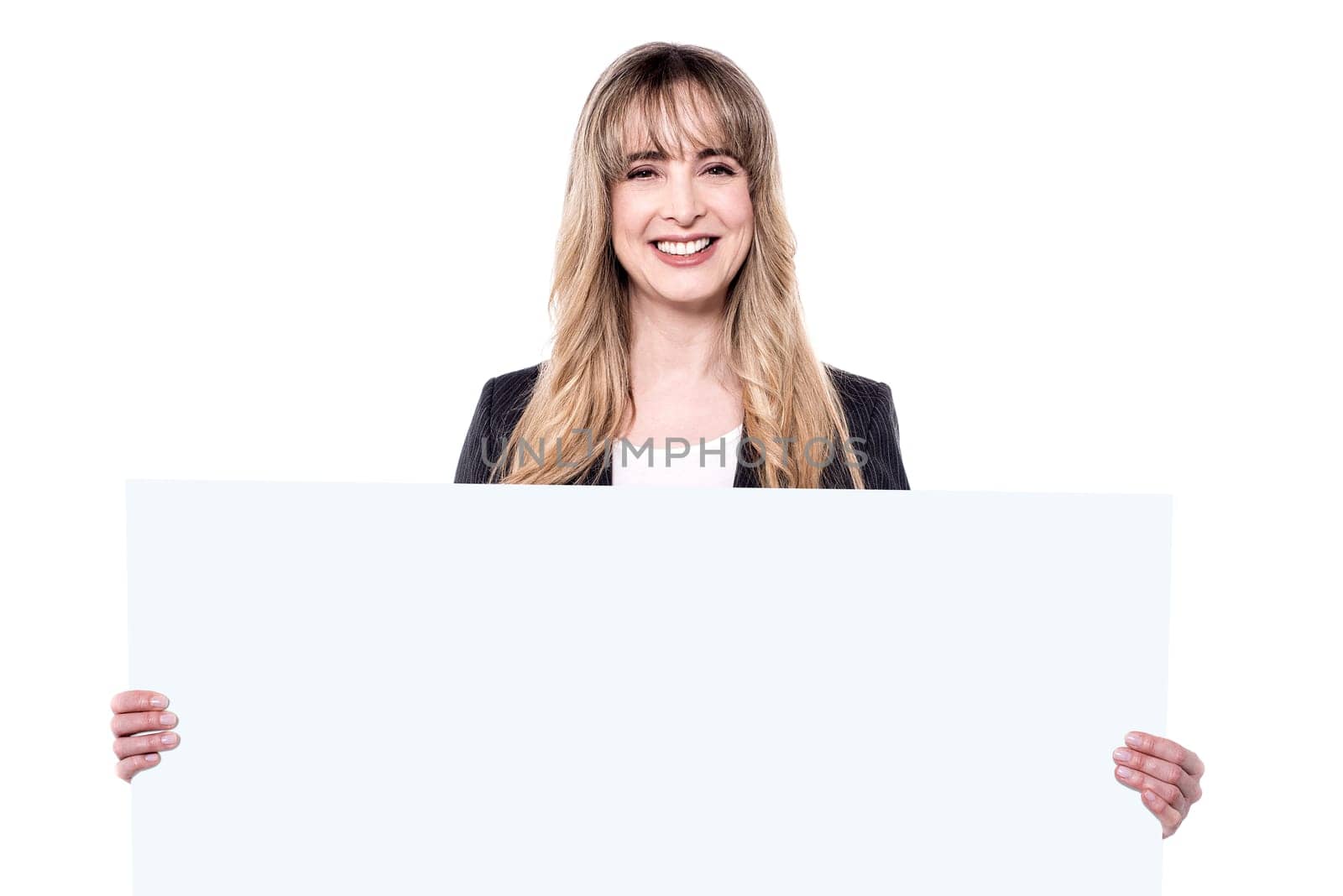 Middle aged smiling beautiful woman standing behind blank white billboard