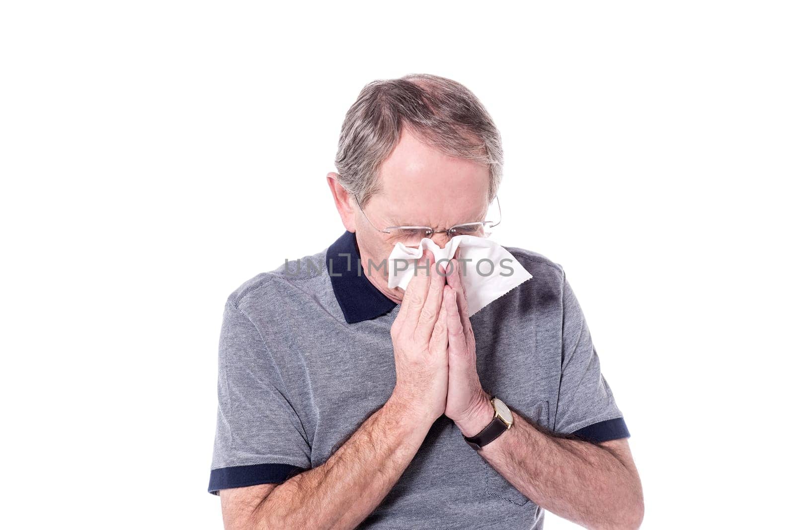 Senior man sneezing, suffering from cold.
