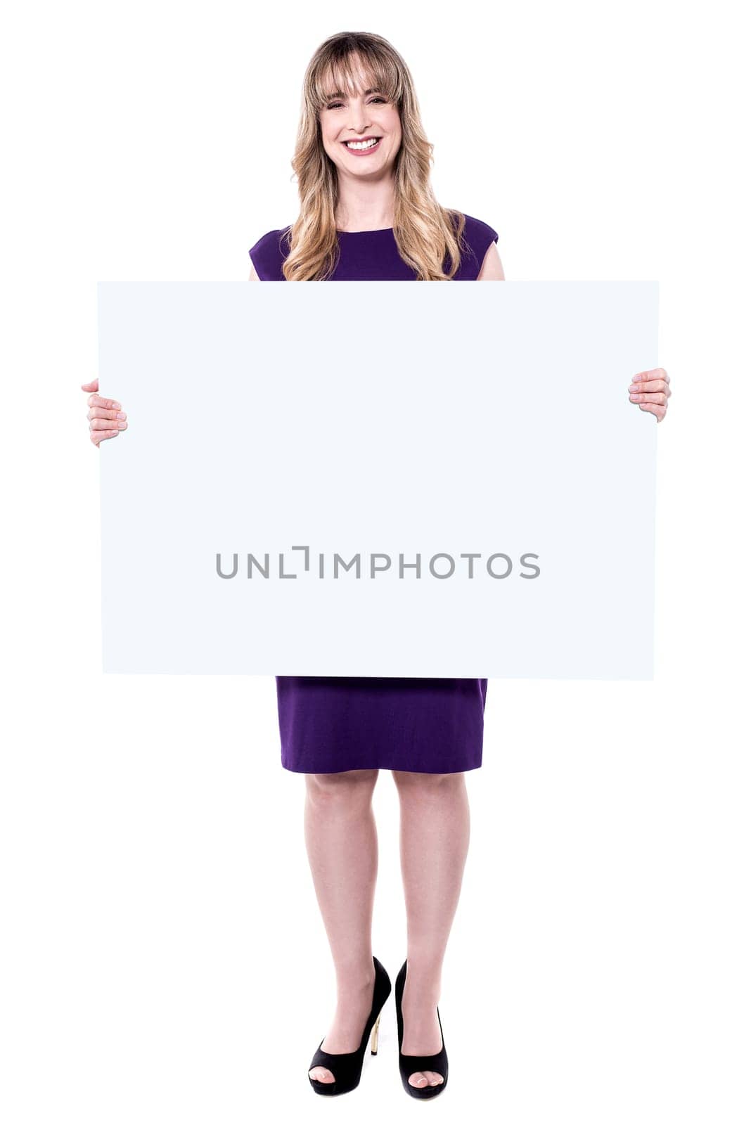 Middle aged woman holding blank ad board and posing to camera.