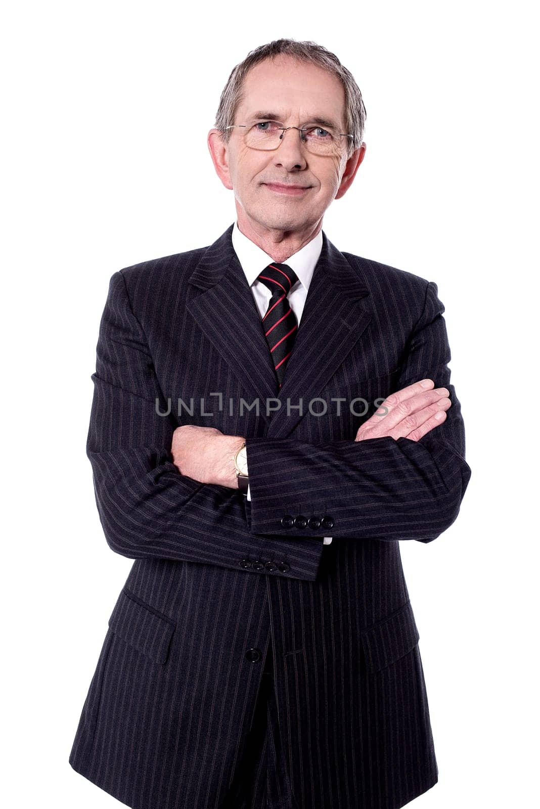 Aged businessman posing to camera with folded arms