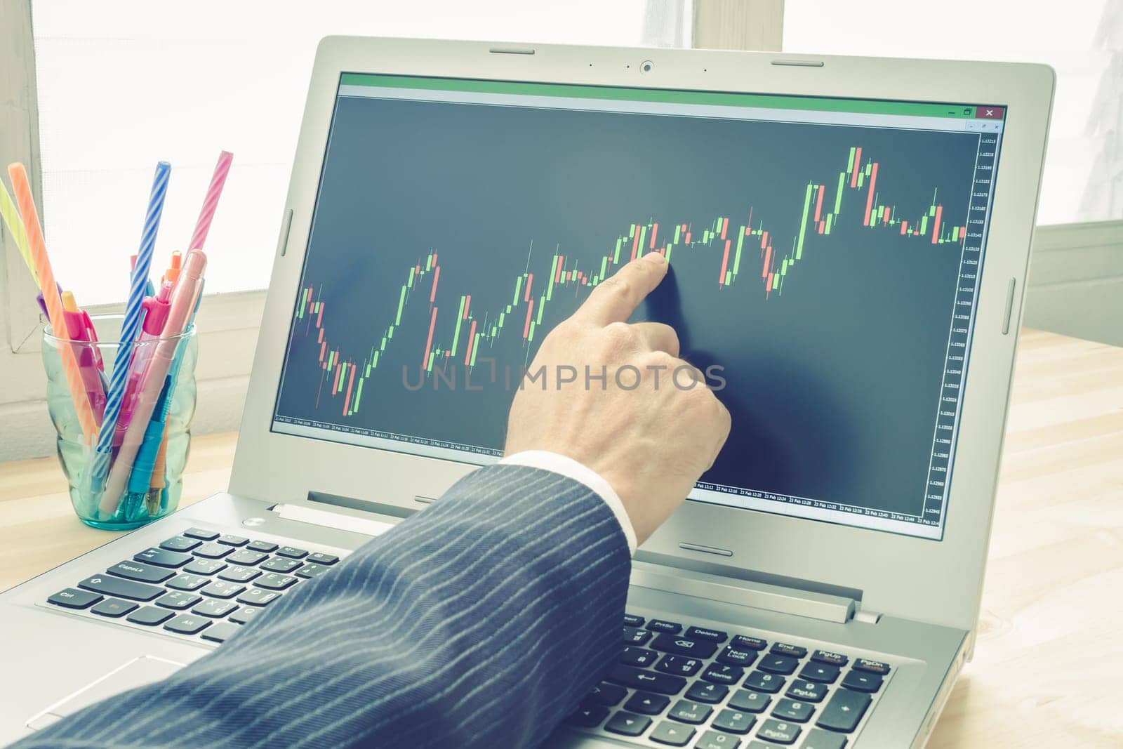 Businessman is pointing stock graph or forex graph . Technical analysis forex or stock by professional trader with pen in vintage style