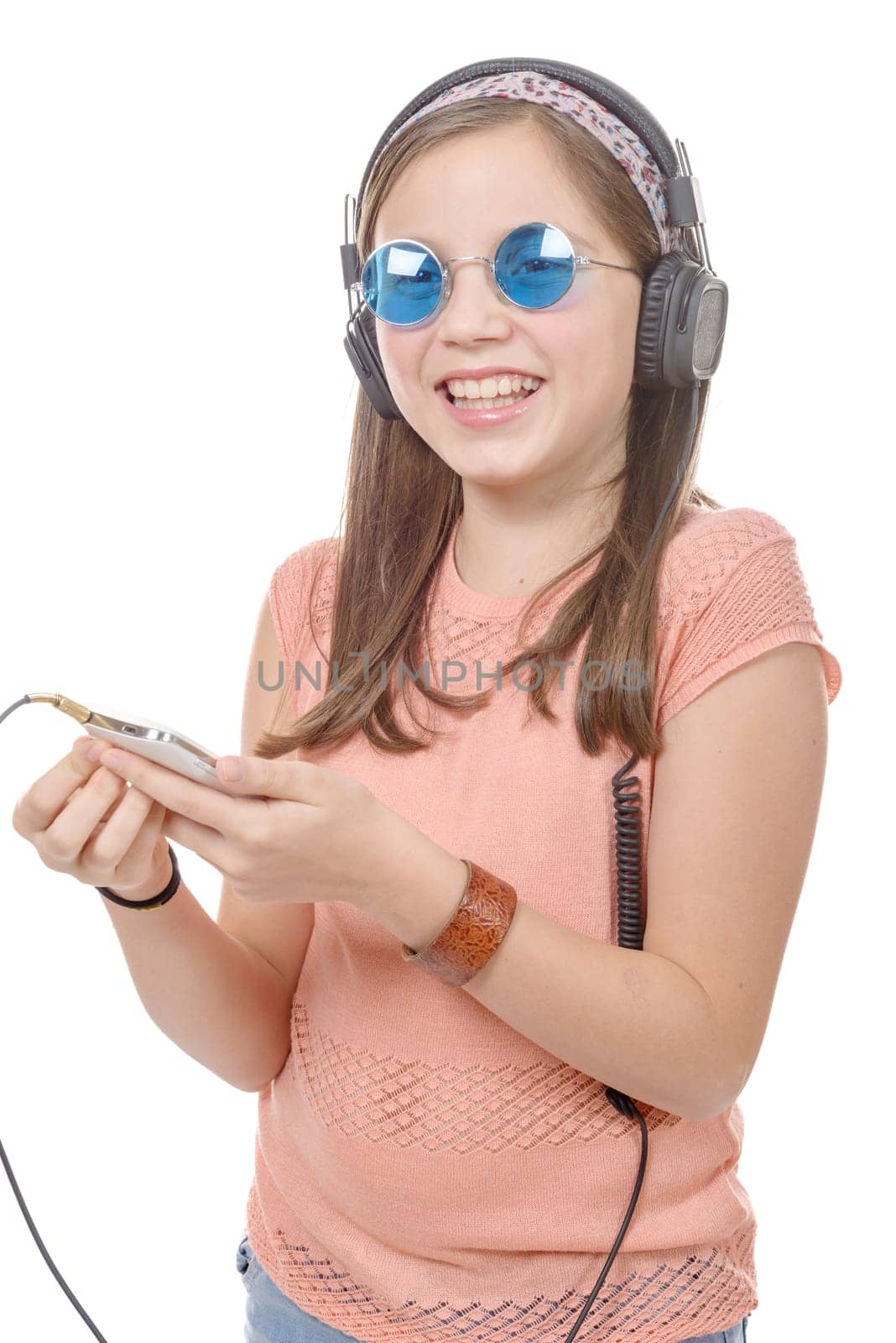 A preteen girl listening to music with his smartphone, on white