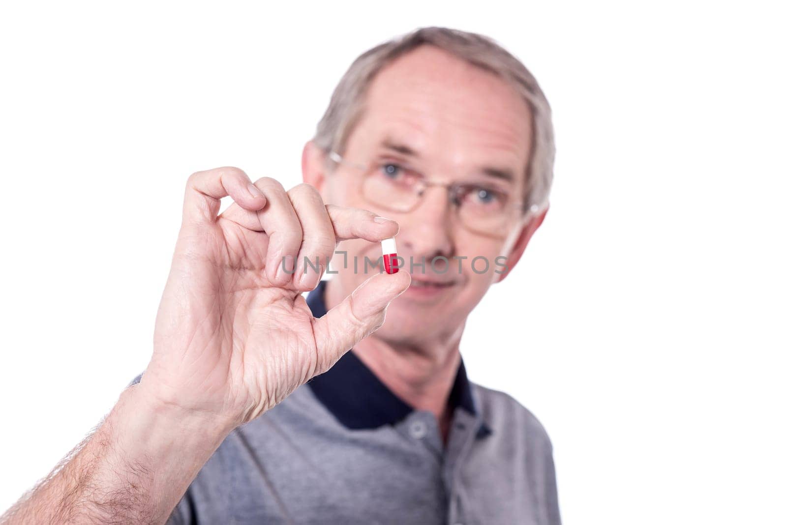 Senior man holding a pill ready to take some medicine