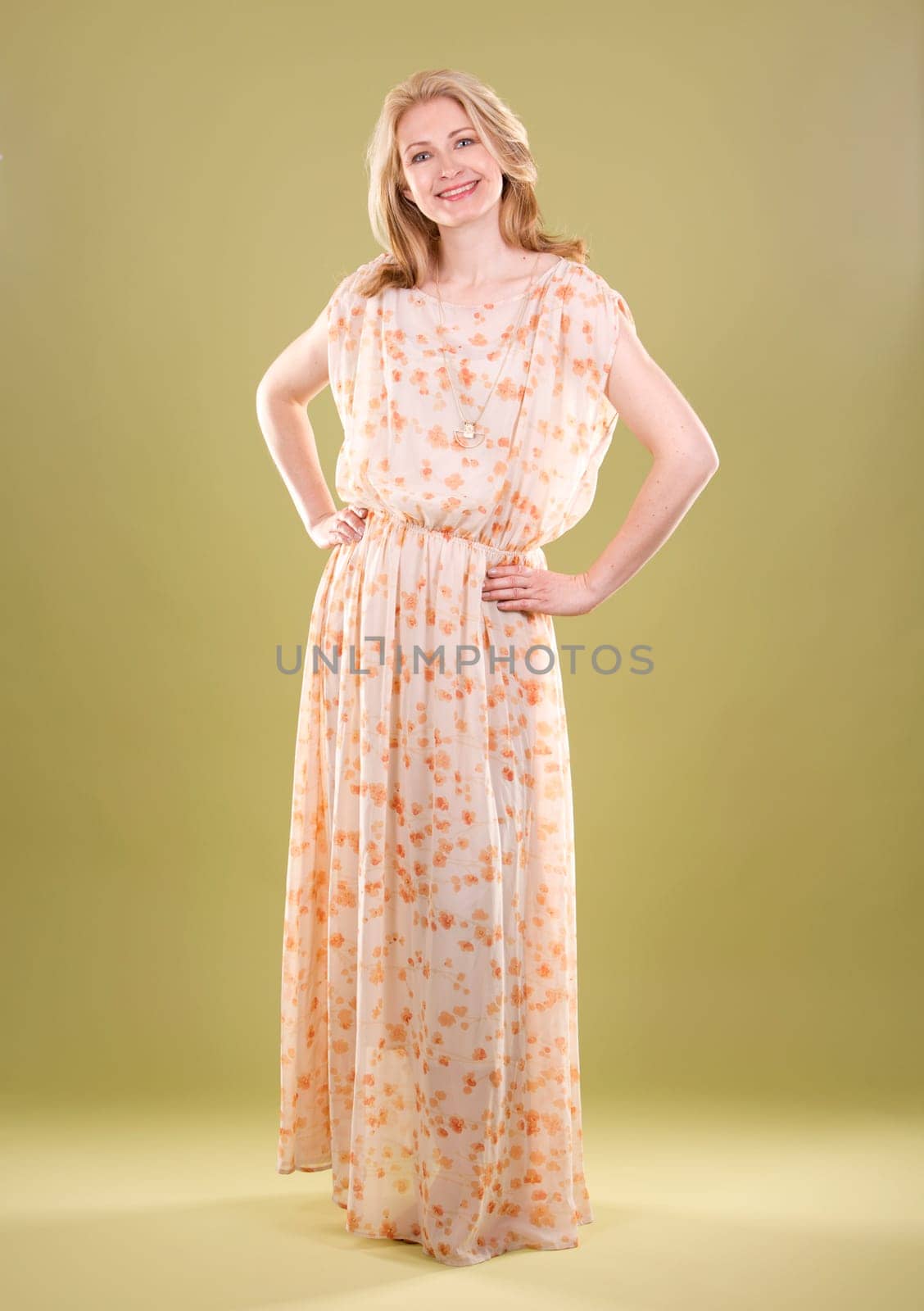 blond woman wearing beige dress on green background