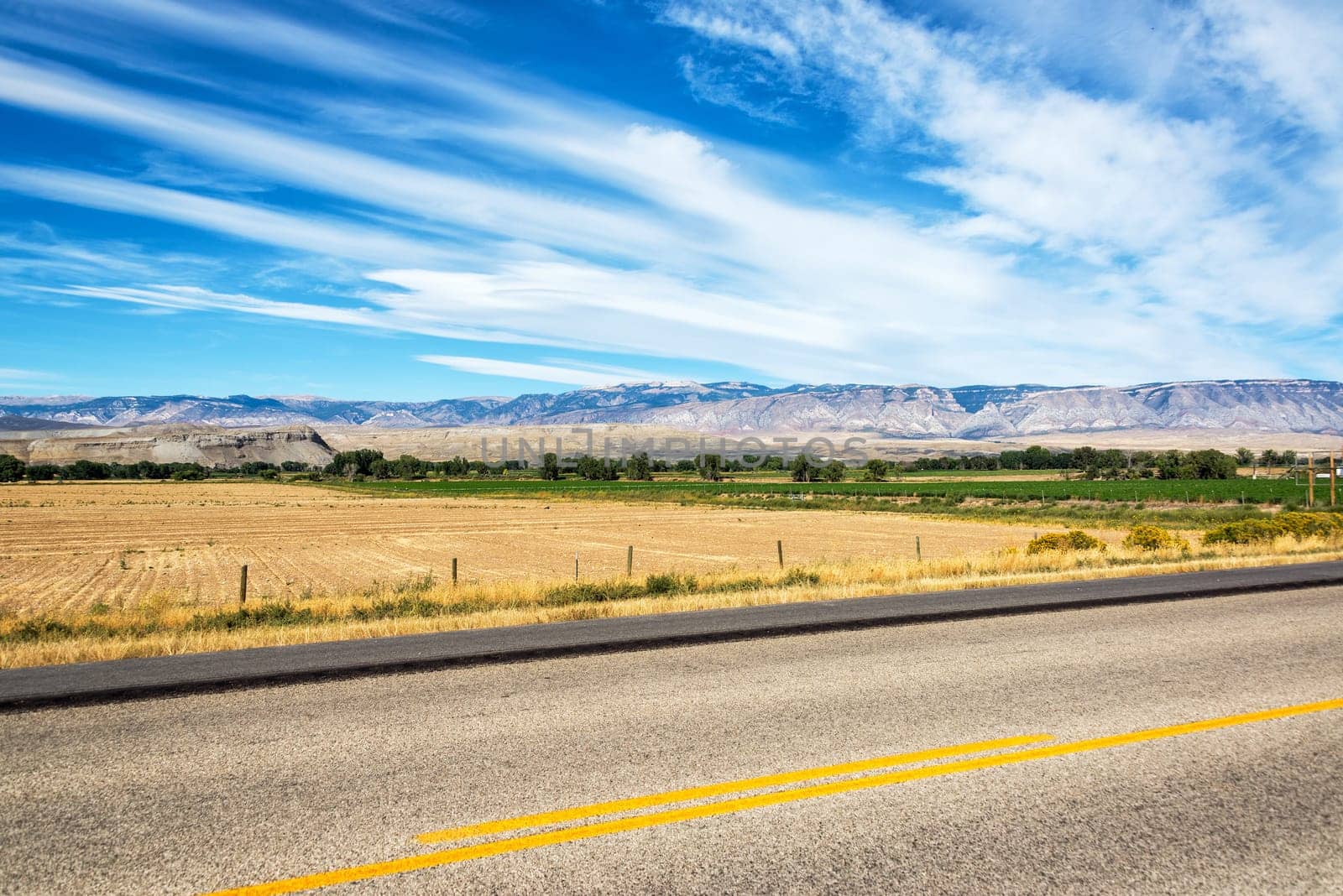 Highway passing through fields in Shell, Wyoming