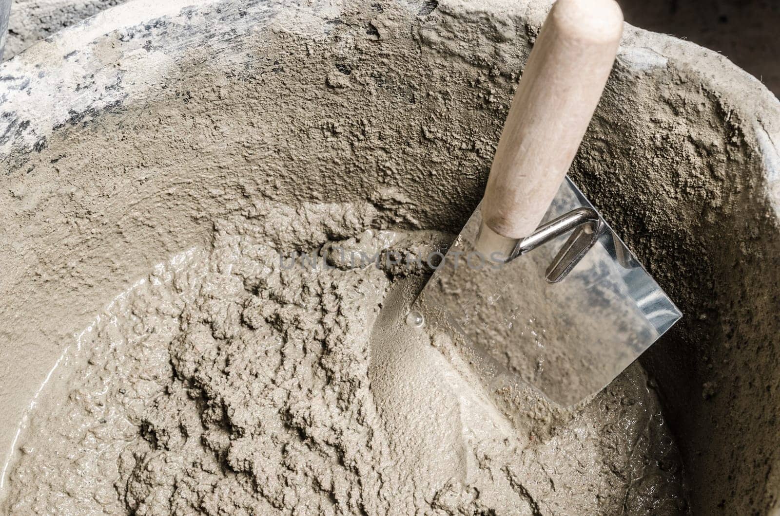 A bucket with a solution and a trowel, close-up