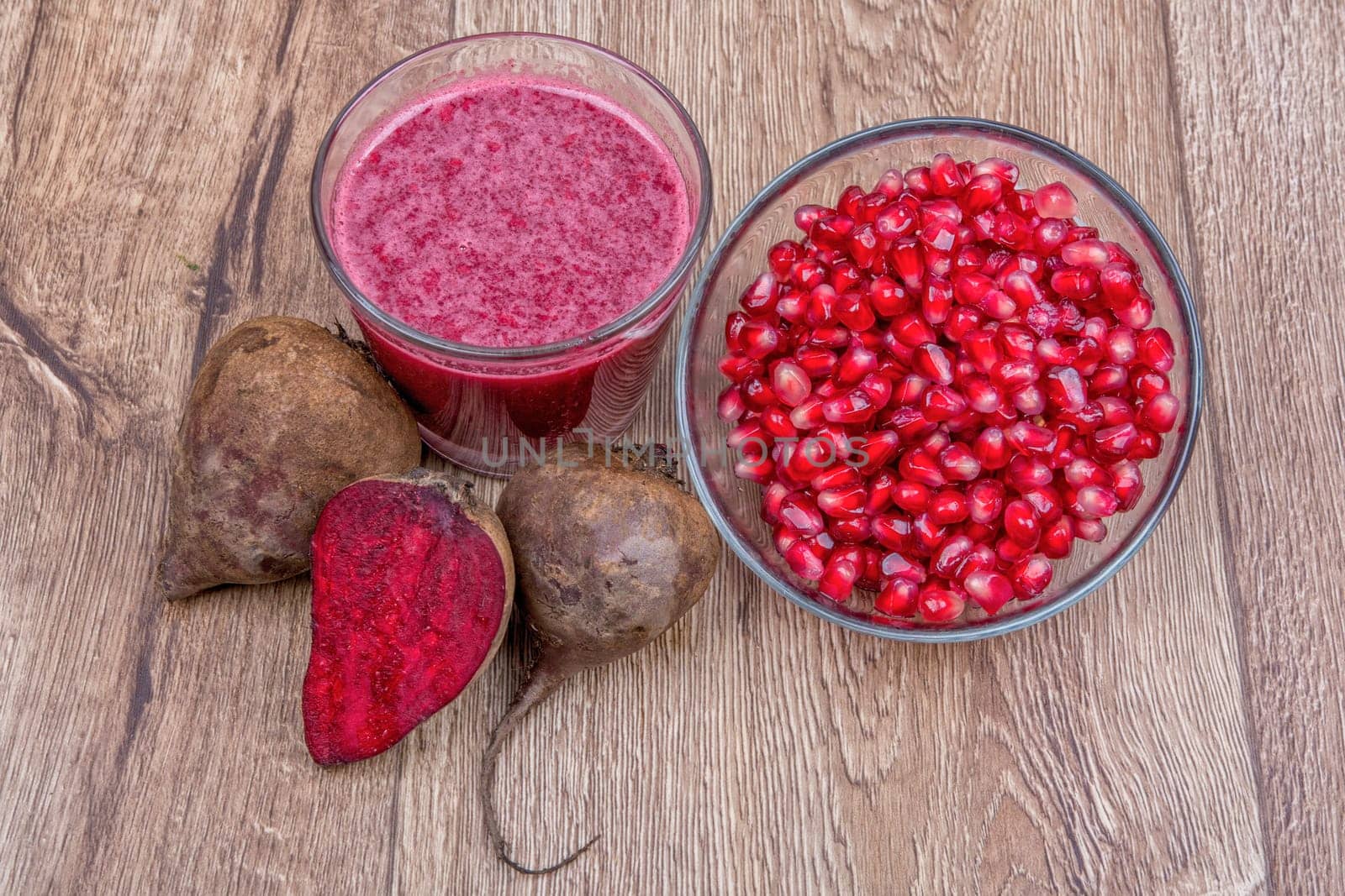 Blended fruit smoothie with ingredients on wooden table