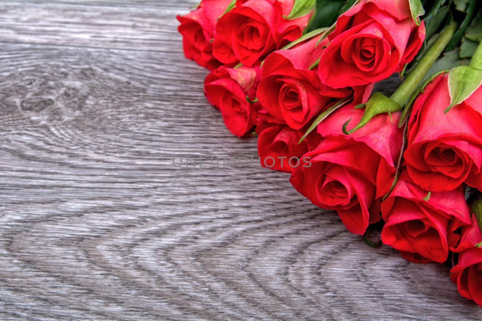 Red roses on a grey wooden background
