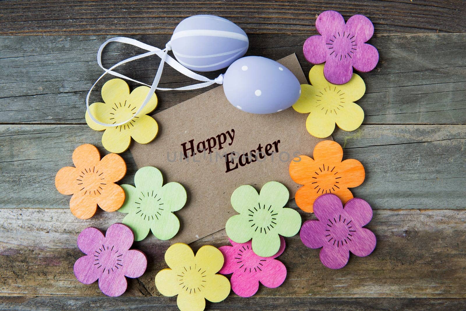 Happy Easter greeting card surrounded by Easter eggs and flowers.