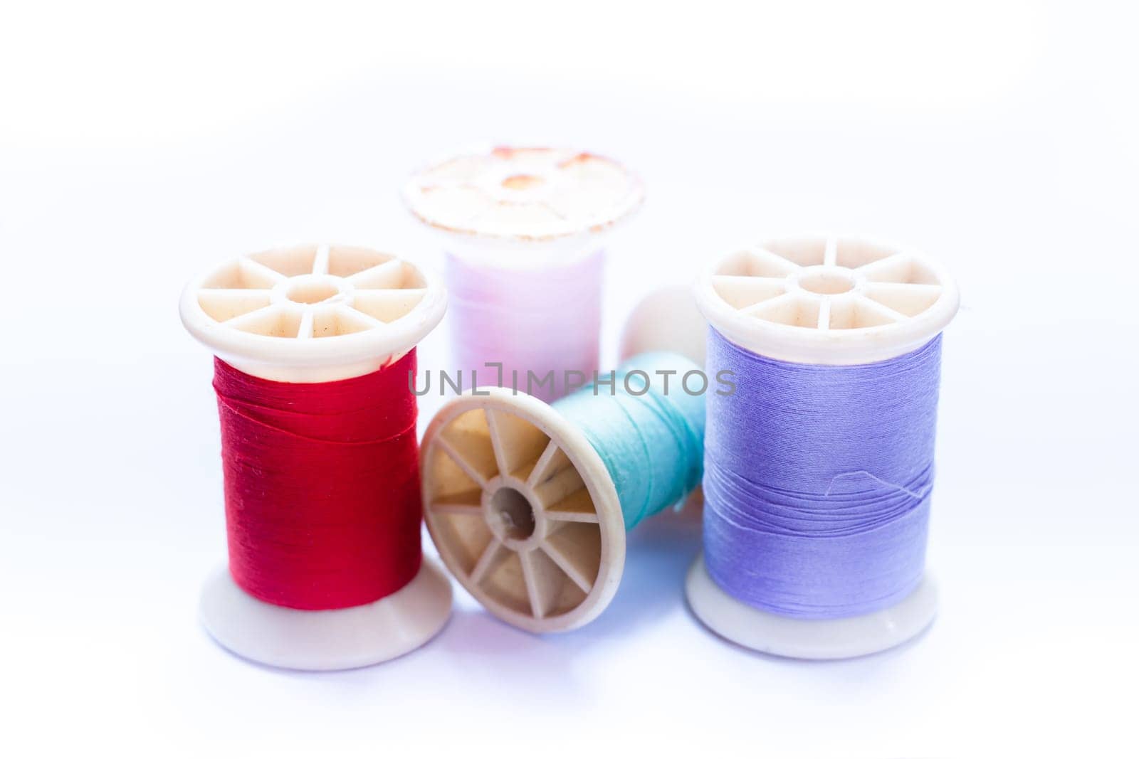 Vintage grunge colorful thread spool on white background, stock photo