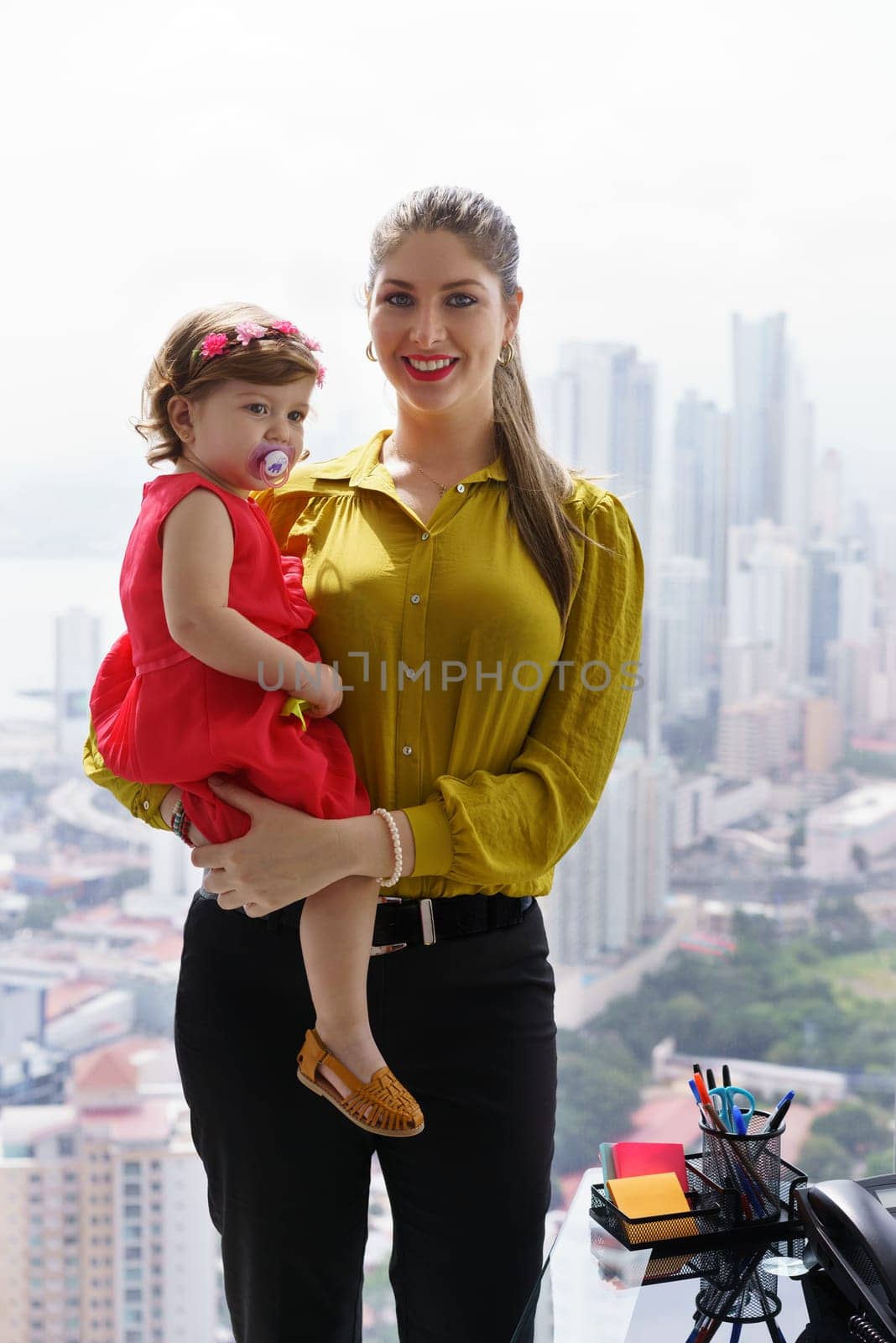 White businesswoman with little daughter in office. The executive mom spends time with her child and takes her at work