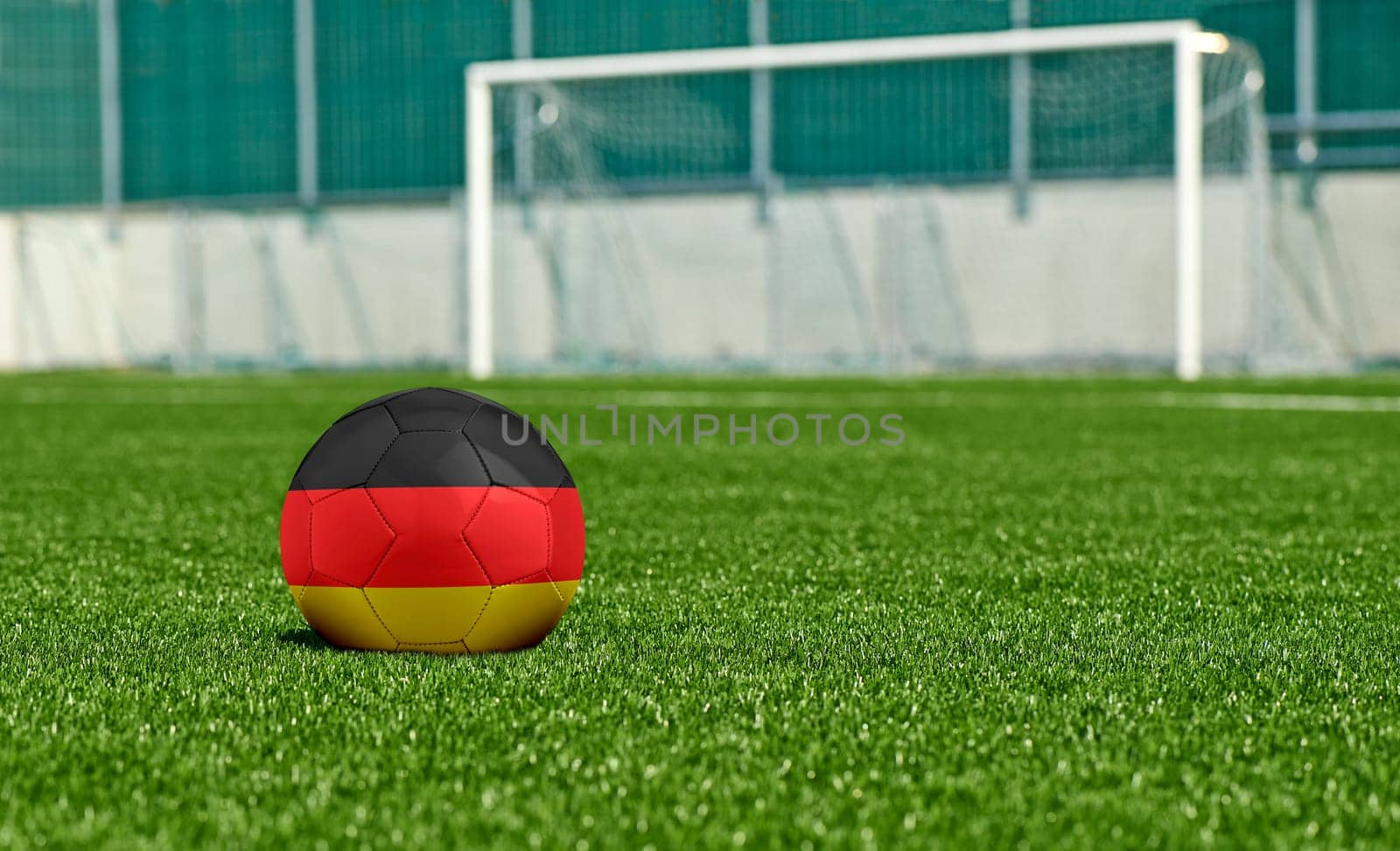 Soccer ball with the flag from Germany on the green field