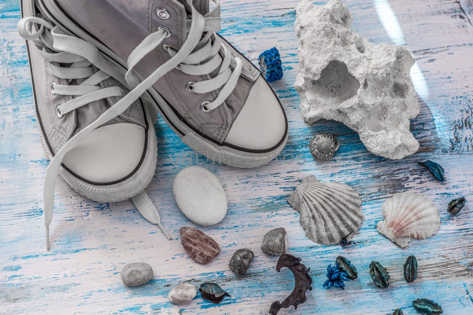 Travel stll life with sneakers and stones on wooden board.travel concept