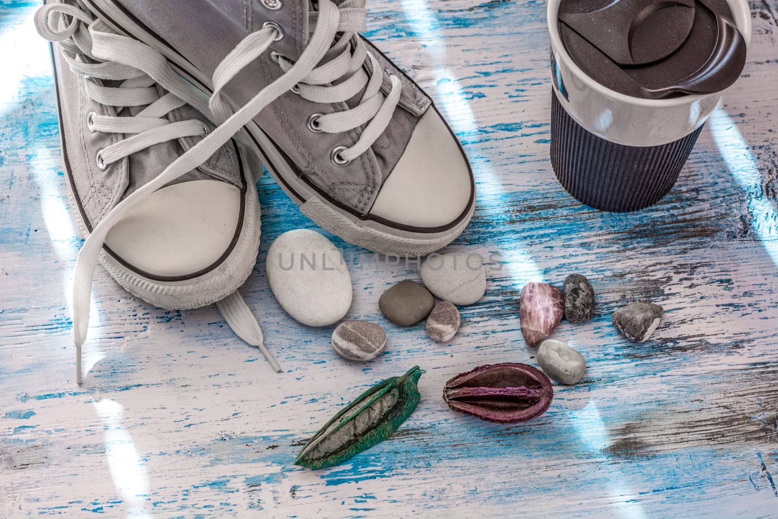 Travel stll life with sneakers and mug on wooden board