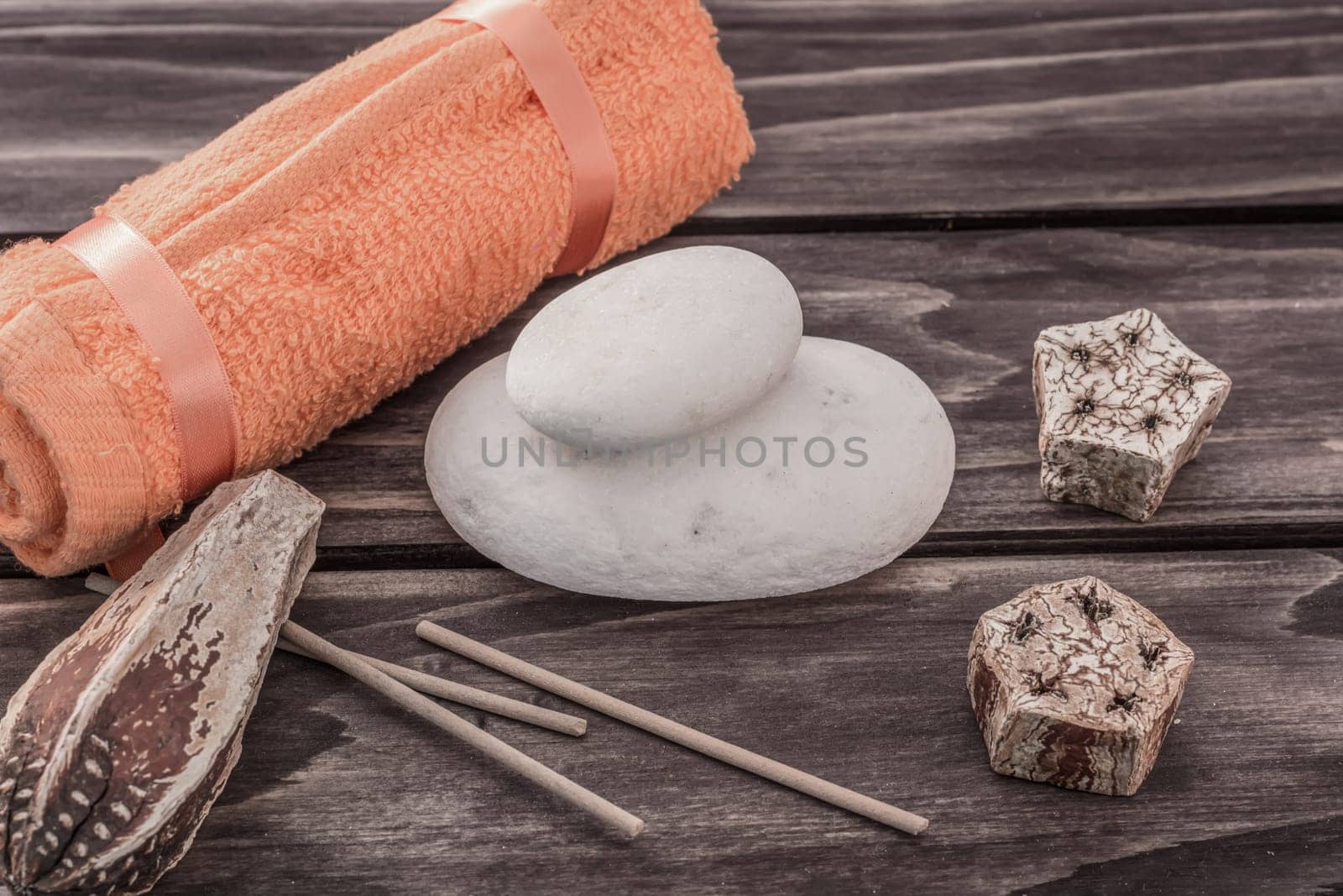Spa concept with towel stones and aroma elements on wooden board
