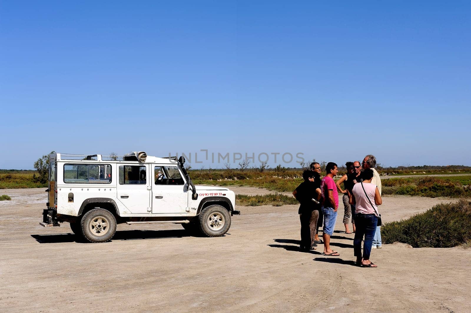 Tourists visiting the Camargue 4x4 with a guide to explain the area and wildlife such as flamingos.