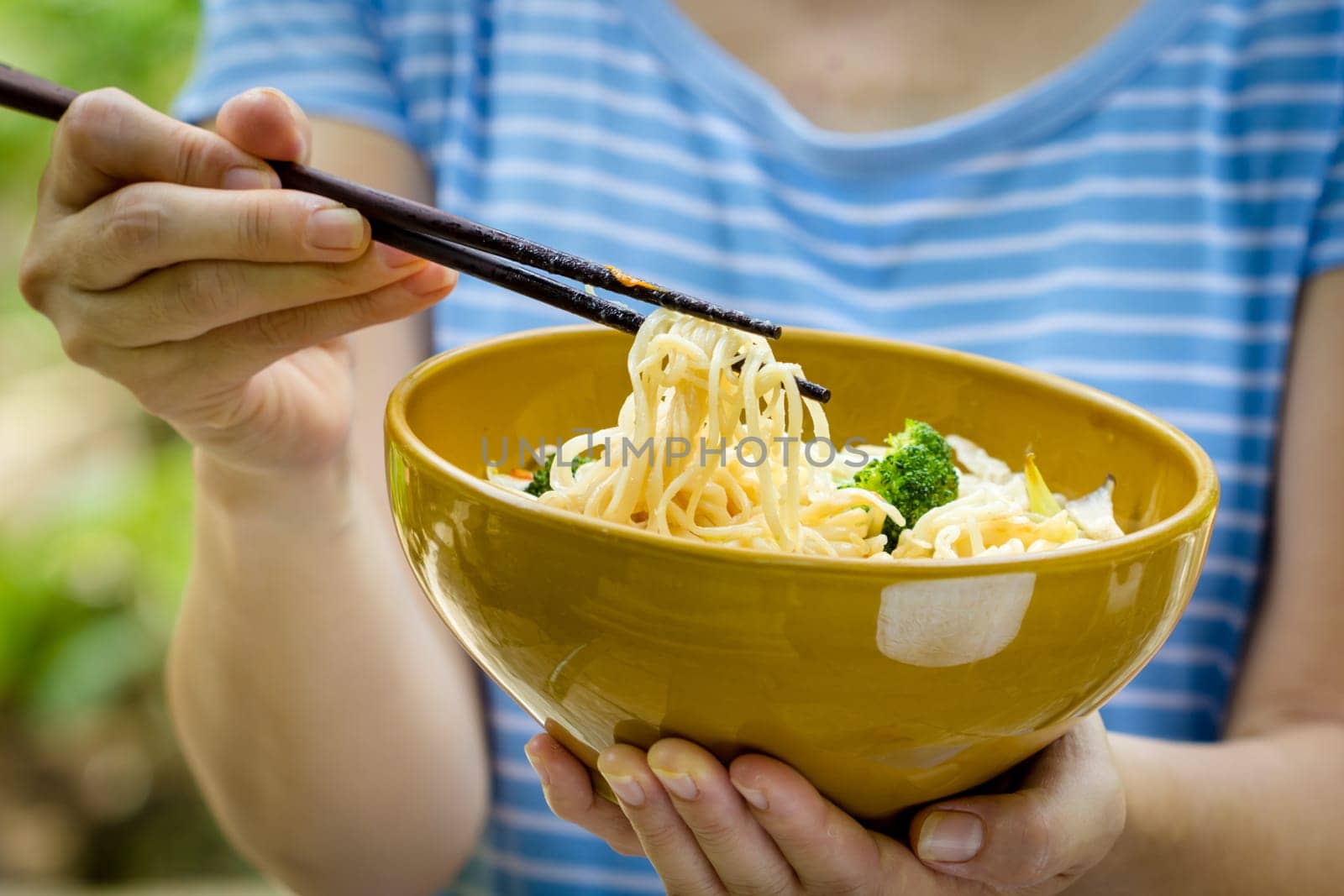woman hand holding a bowl of noodles