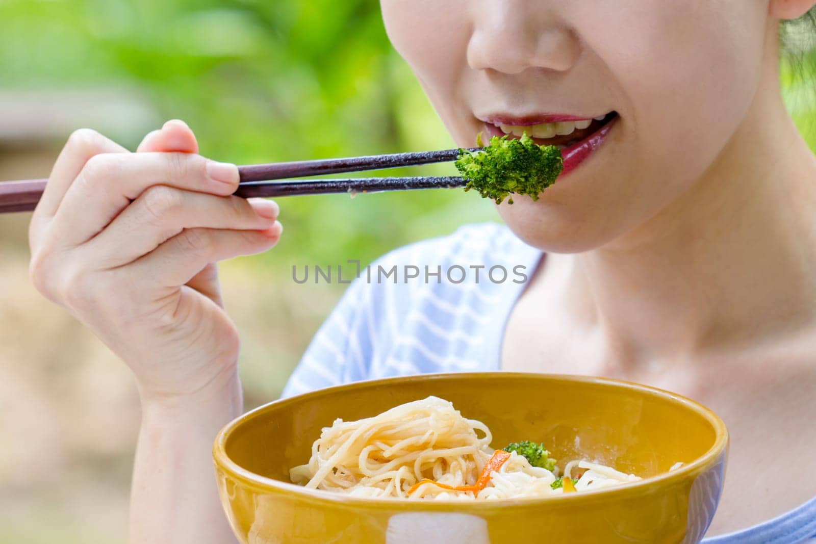 women hand using chopstick eat Broccoli