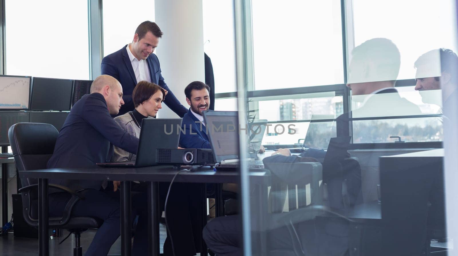 Workplace in modern office with business people brainstorming. Businessman working on laptop during the meeting.