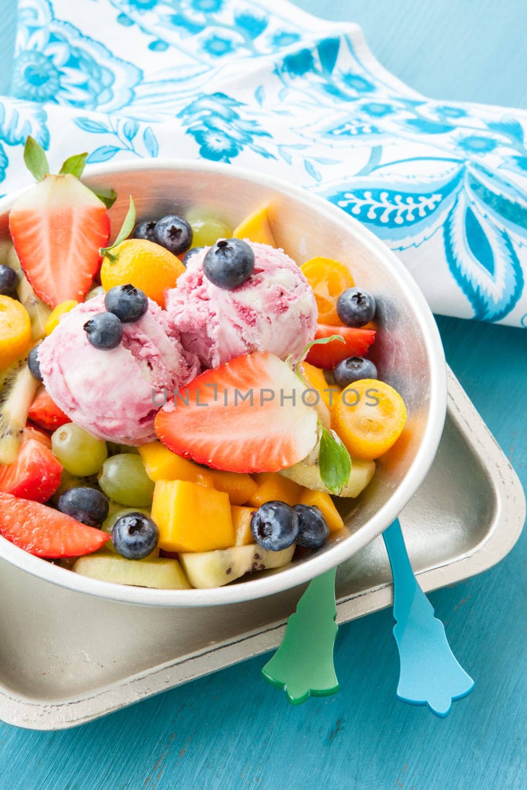 Colourful fruit salad made from fresh fruit and two scoops of ice cream