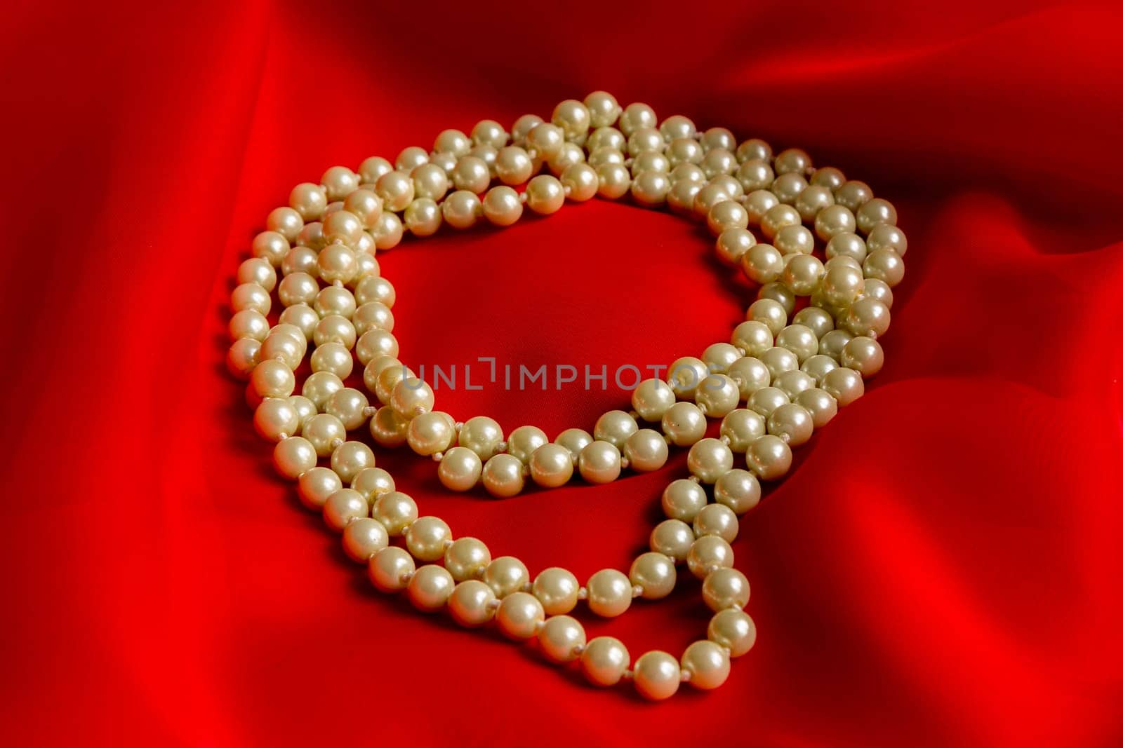 Pearl necklace on a red silk