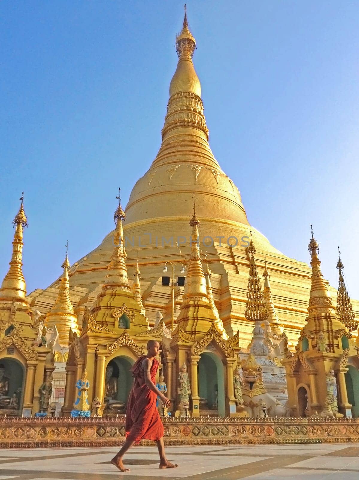 Buddhist monk walking in Shwedagon pagoda, the famous atrraction in Myanmar.